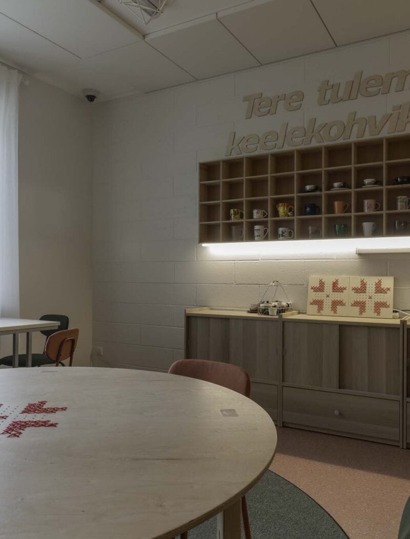 Keelekohvikus ruumis on kasevineerist kohvilauad ja kohvitasside riiul.