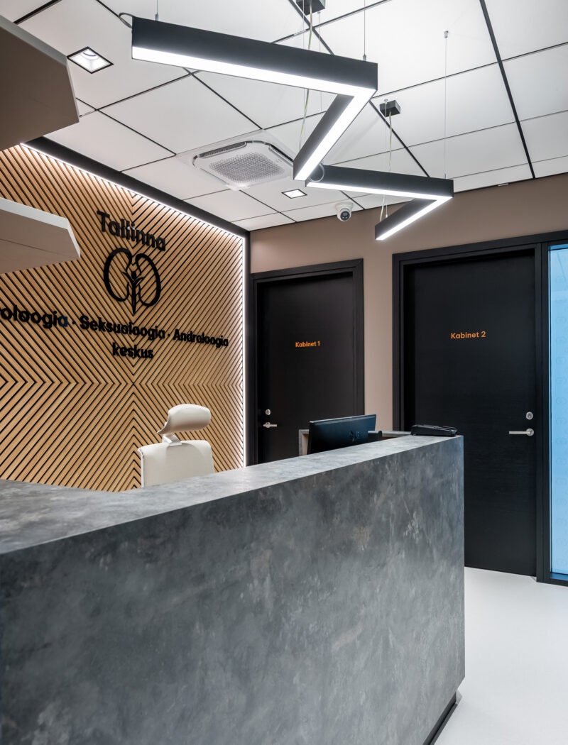 Urology clinic interior with wood, black, and terracotta accents.